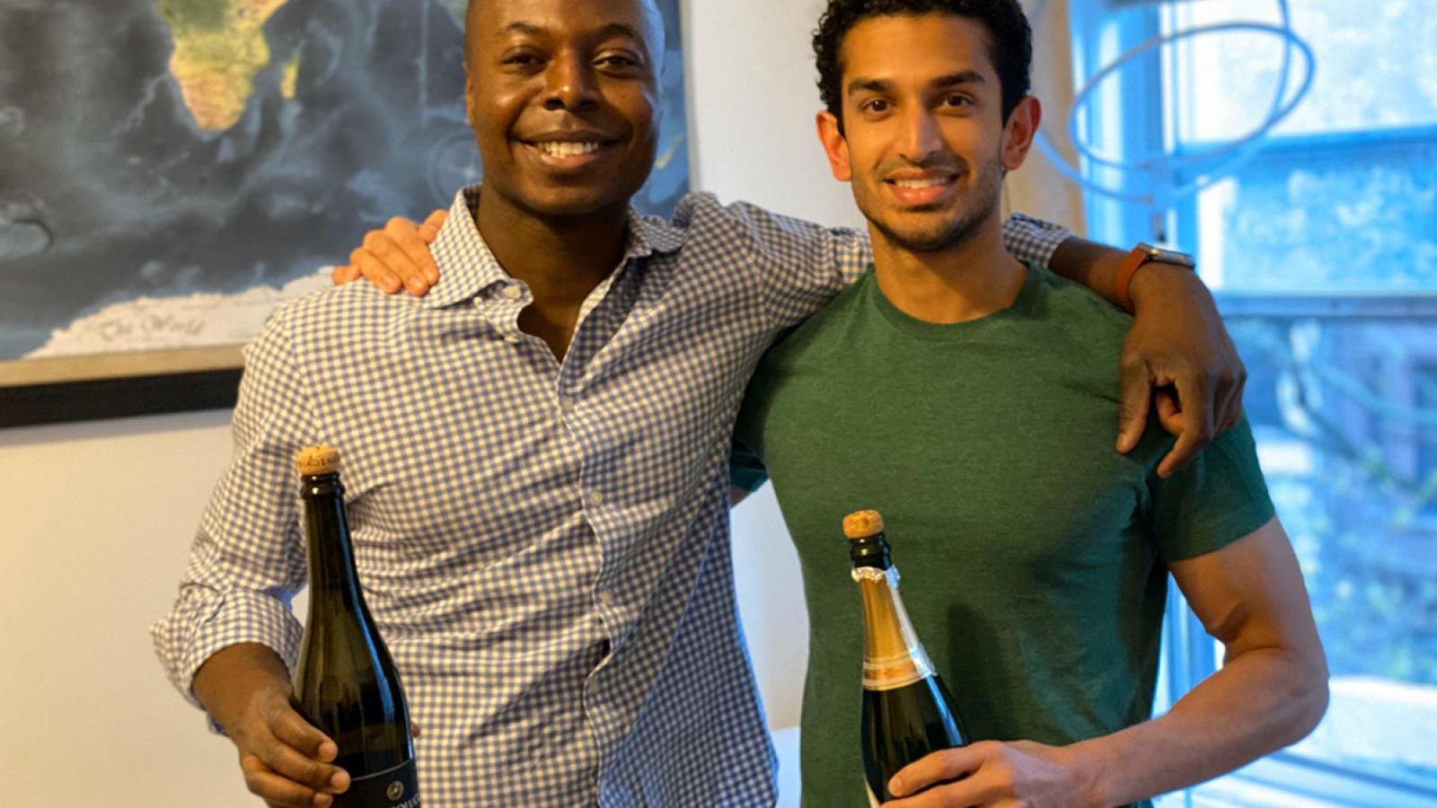 Two residents holding bottles of champagne