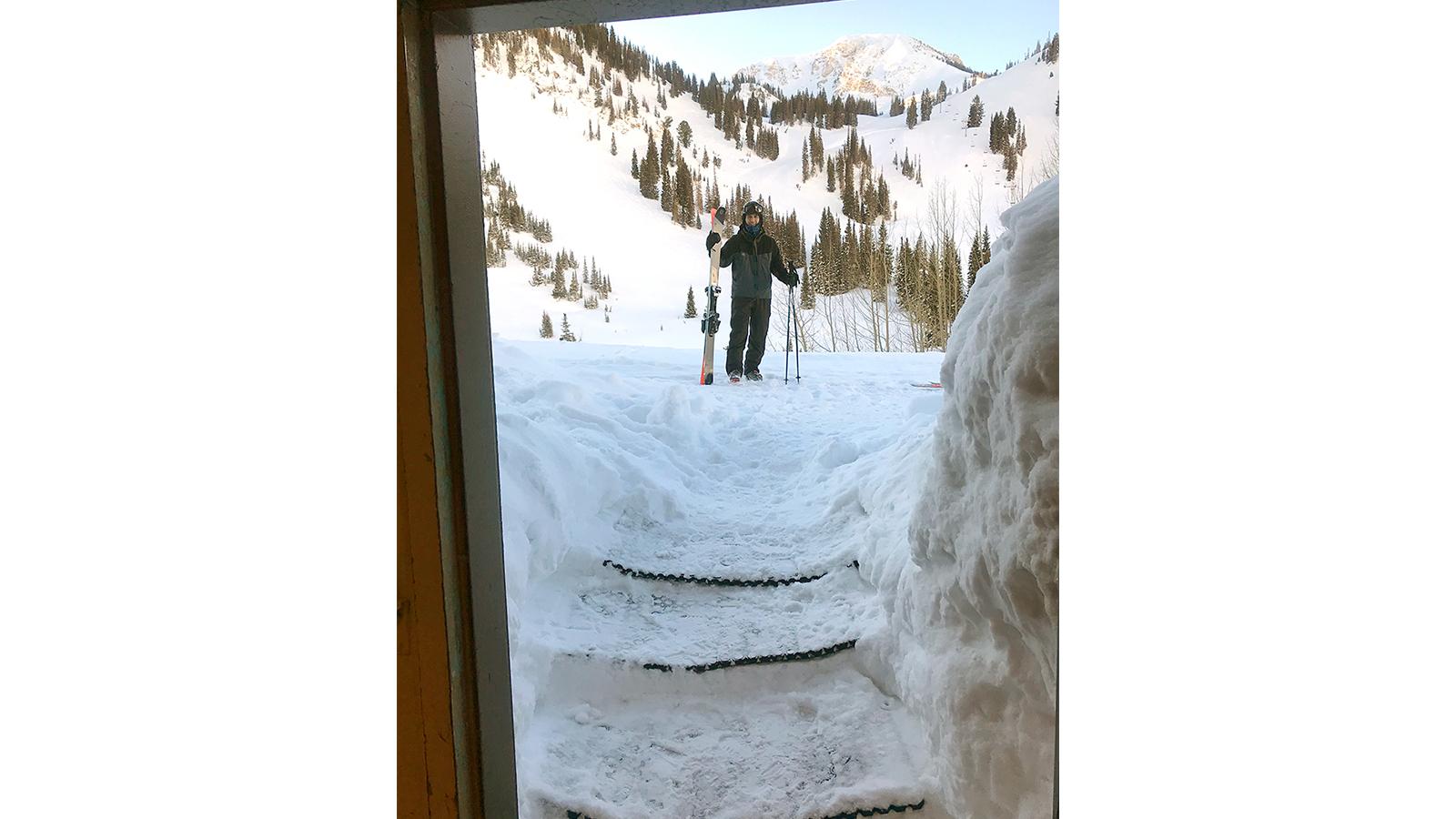 Skier seen in deep snow through doorway