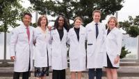 Group shot of the NYOH Class of 2028 residents in their Columbia white coats. From L-R: Drs. Obana, Czerwonka, Smith, O'Connor, Ruberto, and Ashinsky