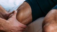 Close up image of a physical therapist manipulating a patient's quadricept