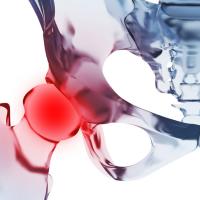 An internal visualization of the hip bone with a red glow focused on the femur joint